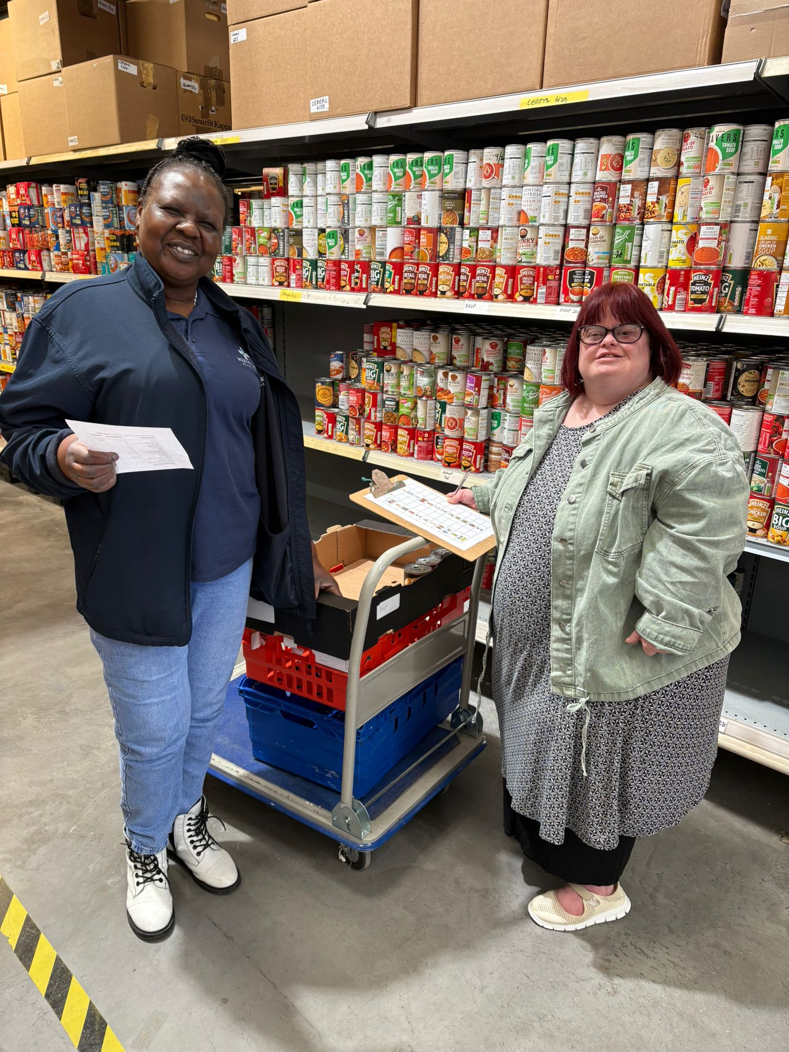 Brandon Trust worker and client standing in front of a shelf of tins.